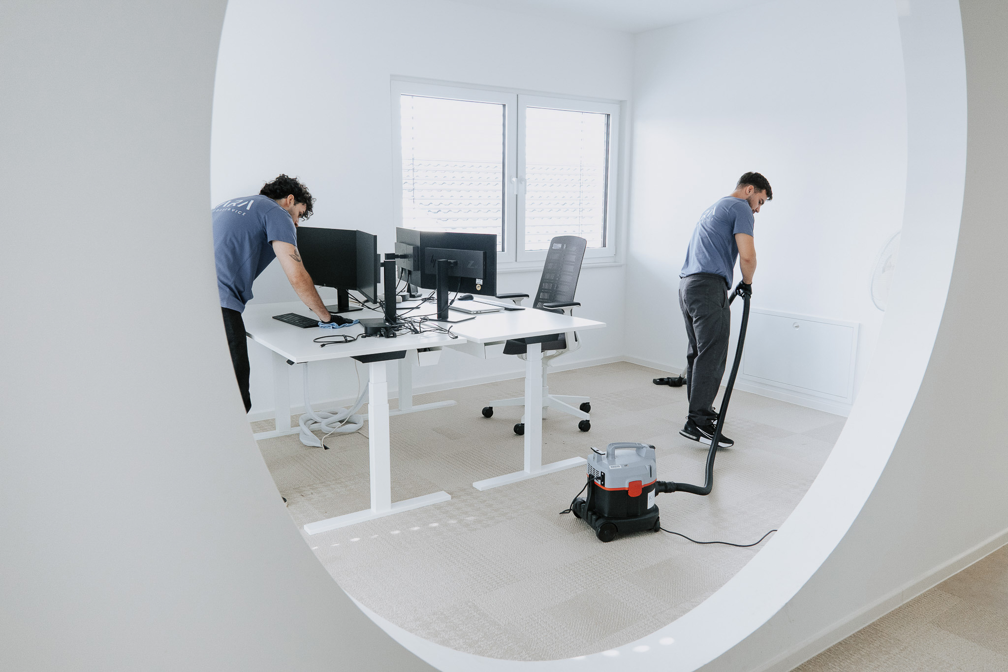 Reinigungskräfte saugen und wischen Bürotisch
